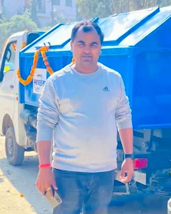 Sujeet Kumar, Director of Nexicycle, standing beside a garlanded waste collection vehicle